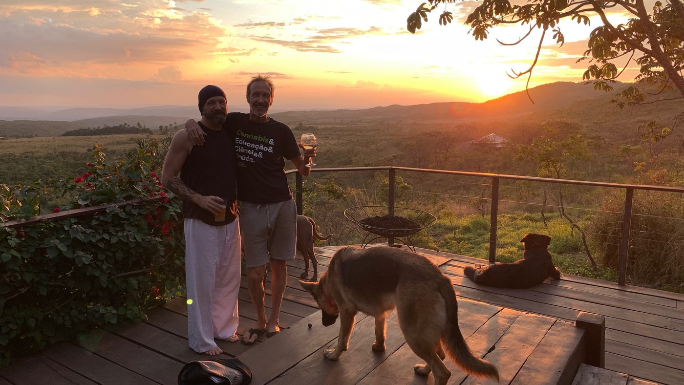 Russ and a friend on a deck at sunset with their dogs